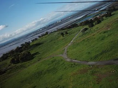 Aerial view of a grassy hillside and the bay