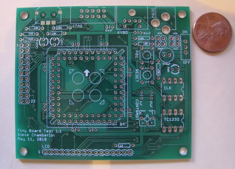 Bare Tiny Board Test PCB next to a penny